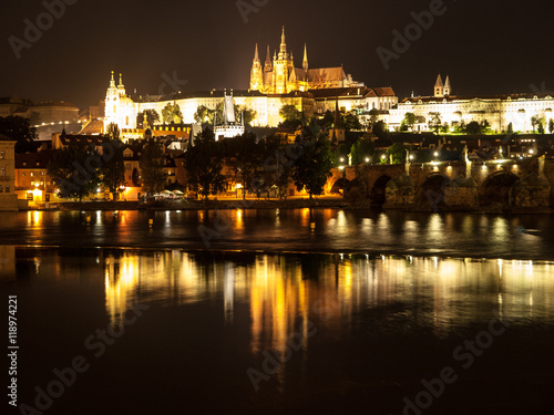 Night Prague Castle with St Vitus Cathedral and Charles Bridge reflected in Vltava river, Prague, Czech Republic