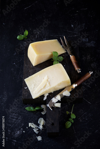 Parmesan cheese with basil on a dark background