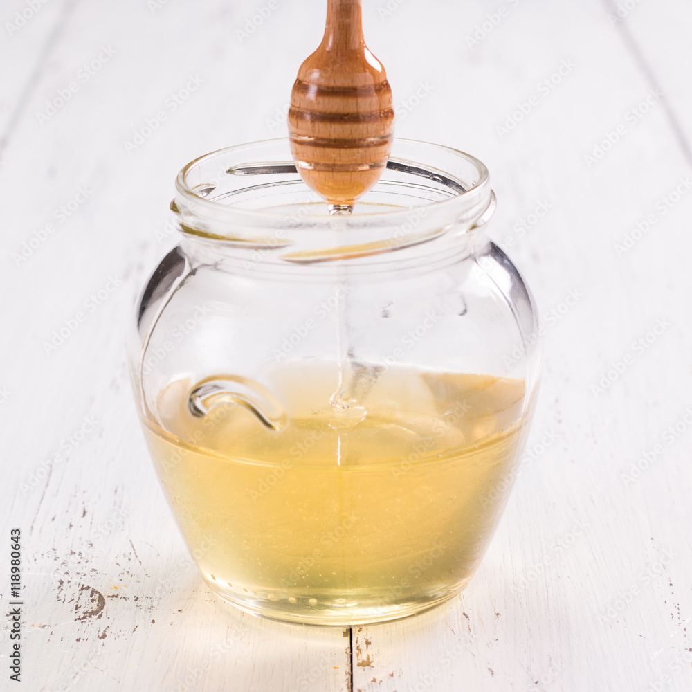 jar of honey with honeycomb on wooden table jar of honey with honeycomb on wooden table