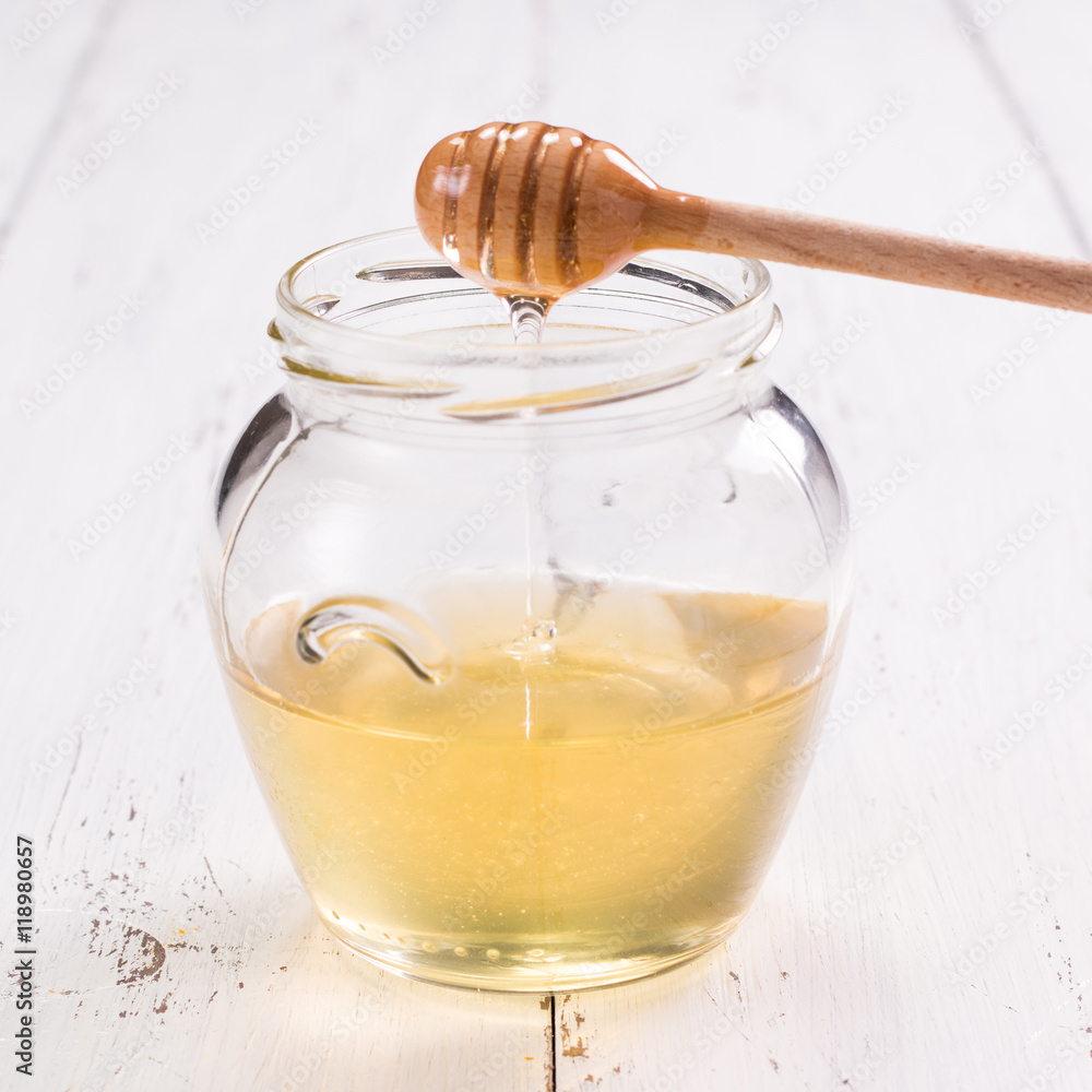 jar of honey with honeycomb on wooden table jar of honey with honeycomb on wooden table