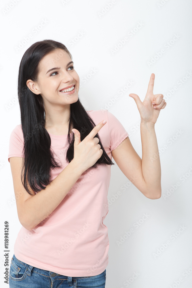 Friendly smiling woman pointing at copyspace isolated on white background Friendly smiling woman pointing at copyspace isolated on white background