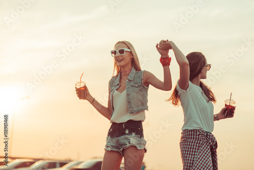 Girls have fun with drinks at the sunset