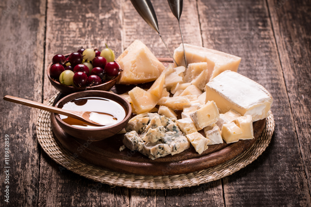 Composition of cheese, berries, bottles and glasses of wine on a wooden table