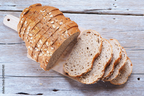 Top view of sliced wholegrain bread on a wooden cutting board.