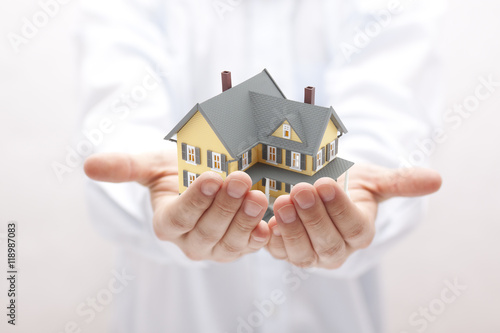 Man holding yellow house miniature