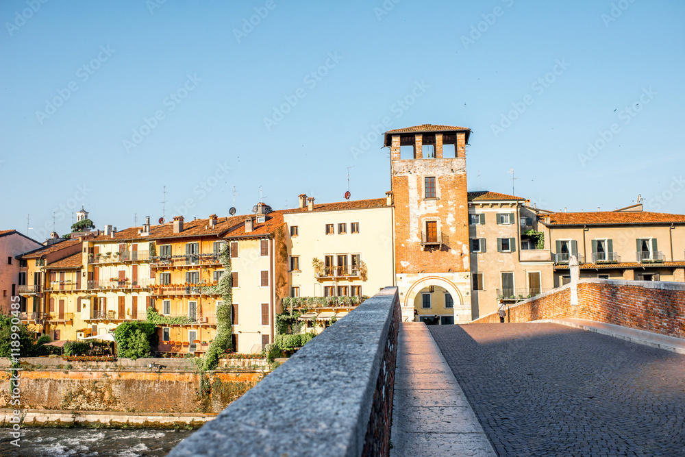 Verona cityscape view on the riverside with historical buildings and watchtower on the sunrise