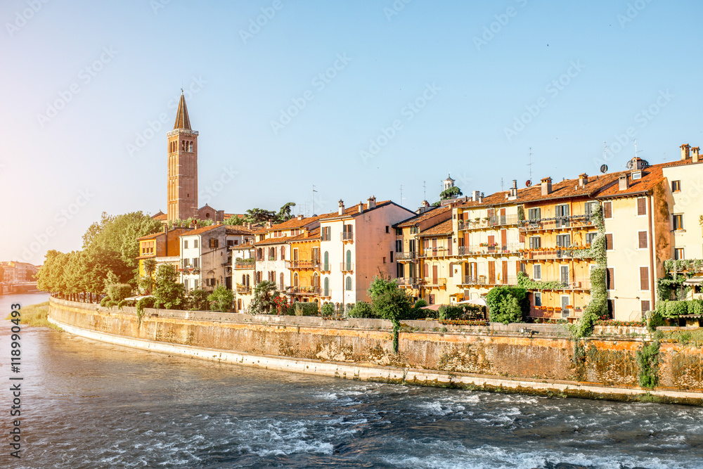 Verona cityscape view on the riverside with historical buildings and tower on the sunrise