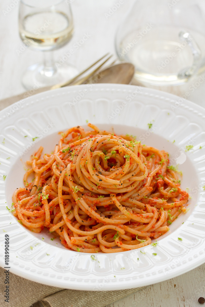 spaghetti with sauce on white plate on white wooden background