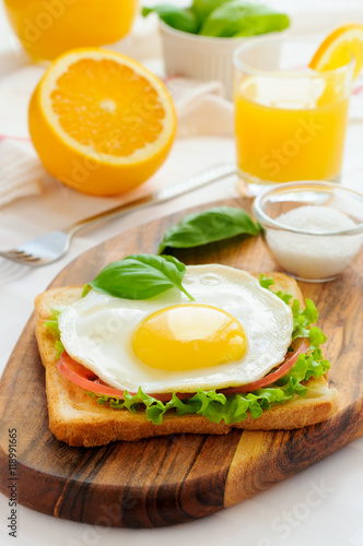 Sandwich with fried egg, tomato, green salad