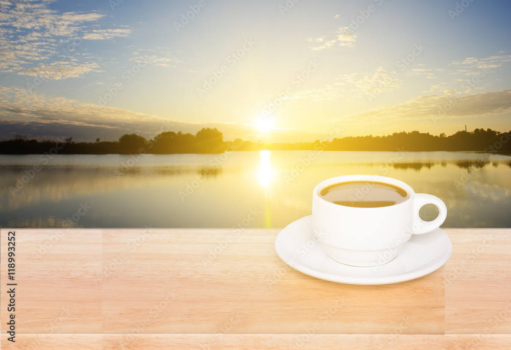 white coffee cup on wood table and view of sunset in the river background white coffee cup on wood table and view of sunset in the river background