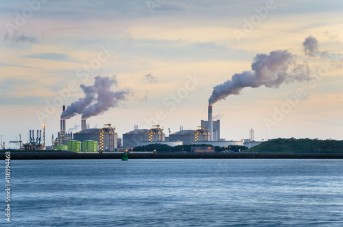 Industrial Plant at Sunset with Smoke coming from the Chimneys photo