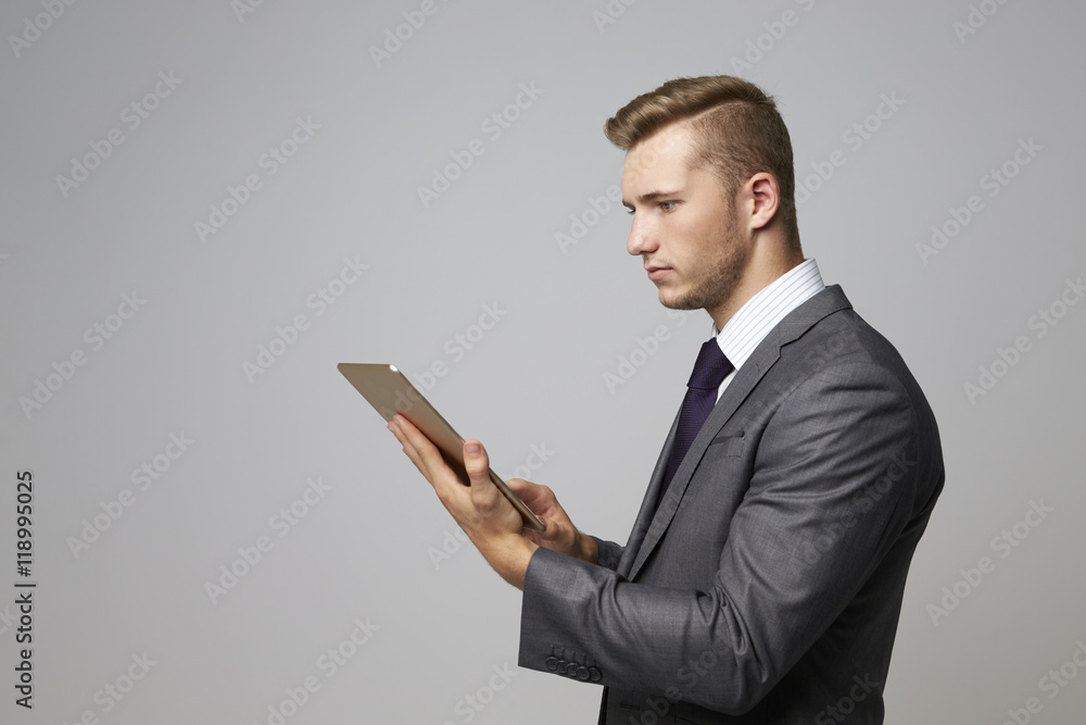 Studio Portrait Of Businessman Using Digital Tablet