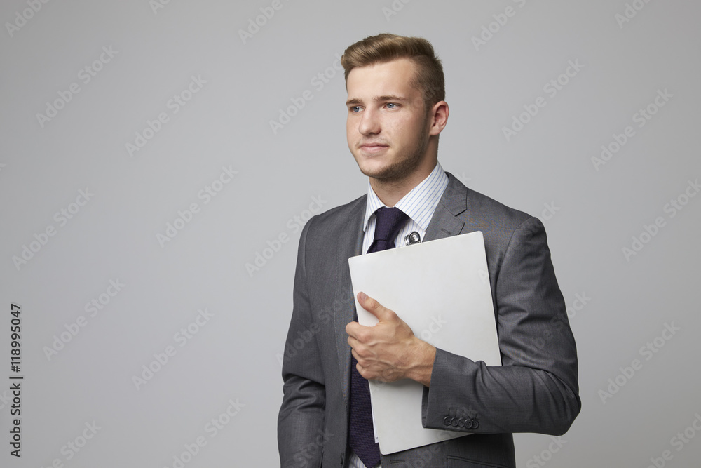 Studio Portrait Of Businessman Holding Clipboard Studio Portrait Of Businessman Holding Clipboard