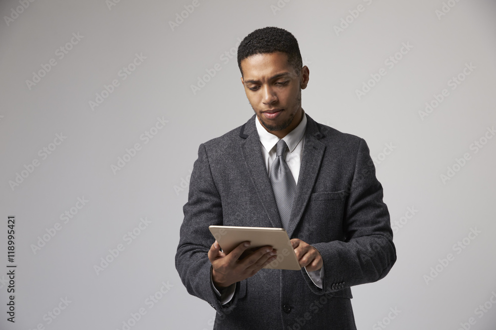 Studio Portrait Of Businessman Using Digital Tablet