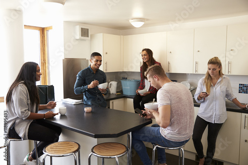 Students Relaxing In Kitchen Of Shared Accommodation © Monkey Business