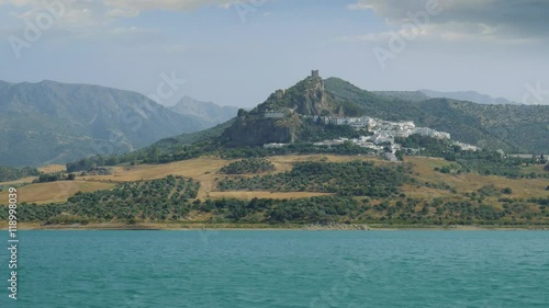 Old castle on a hill top with a small medieval town near a lake