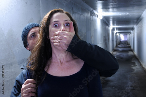 Man attacks a woman from behind in a dark tunnel