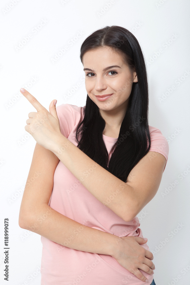 Friendly smiling woman pointing at copyspace isolated on white background Friendly smiling woman pointing at copyspace isolated on white background