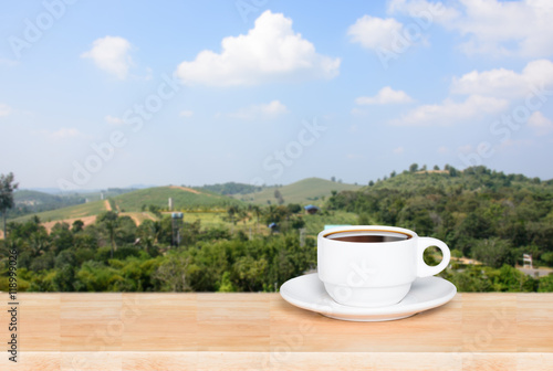 Cup with coffee on table and landscape