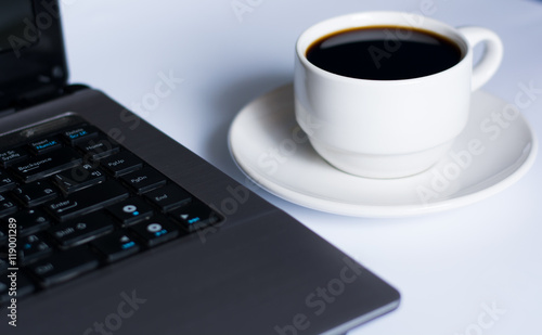 Laptop and coffee cup on white
