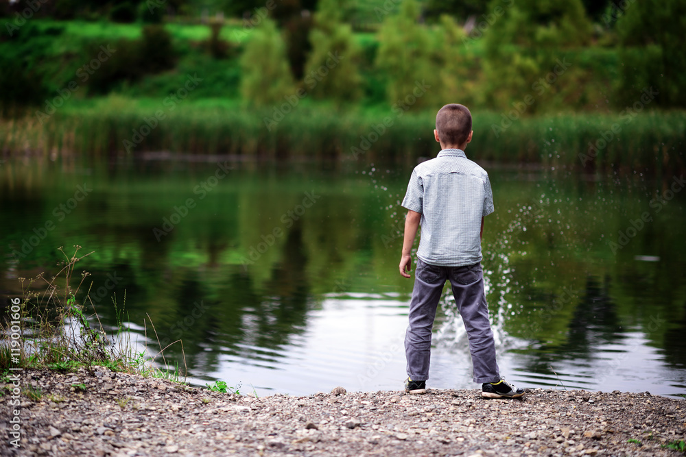 boy throws a stone into the water 