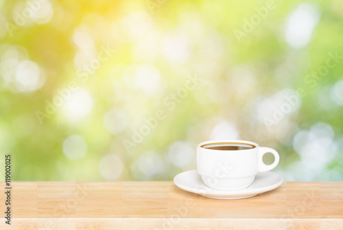 Coffee cup on the wooden table and green bokeh background