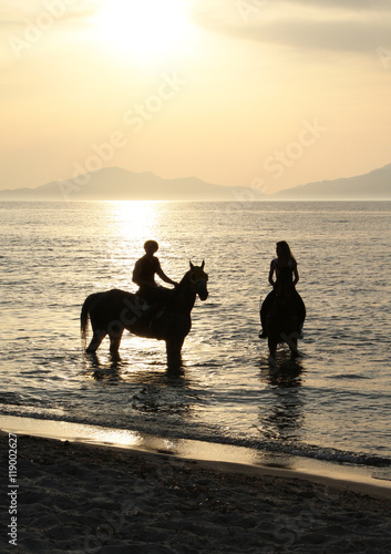 Men and woman on a horse and a gold sunset