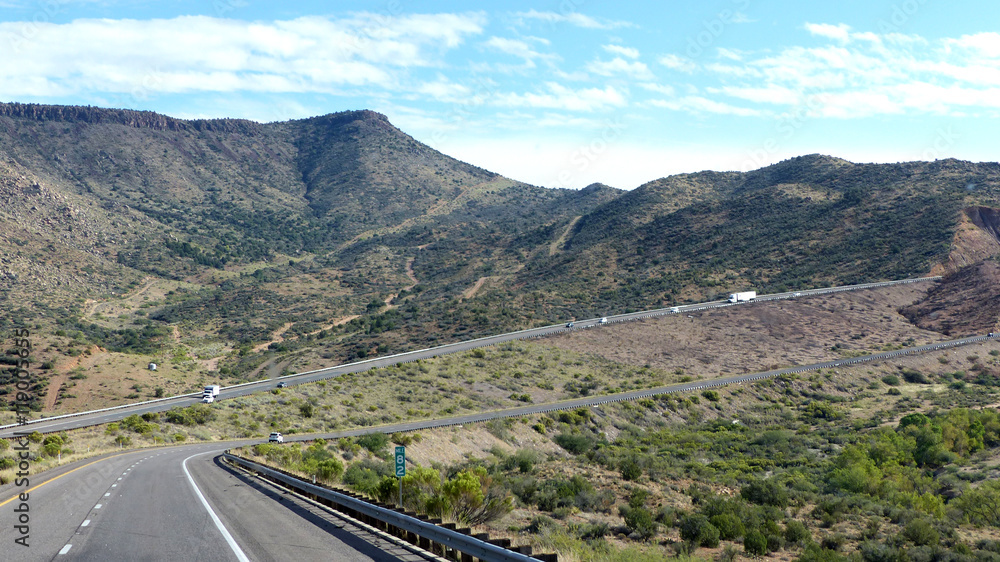 Highway in Arizona in den Vereinigten Staaten/Kurvenreiche Autobahn durch bergige Wüstenlandschaft in Arizona, zweispurige Fahrbahn und Standstreifen