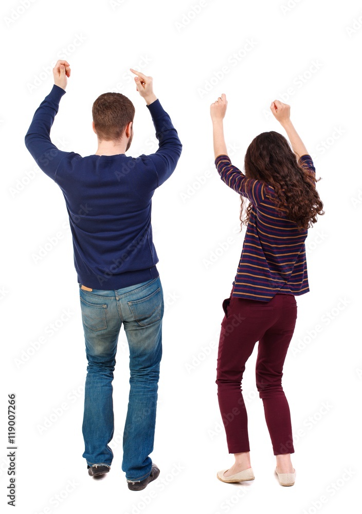 Fototapeta premium Back view of dancing young couple(men and women). Swarthy girl and a bearded man celebrating their victory.