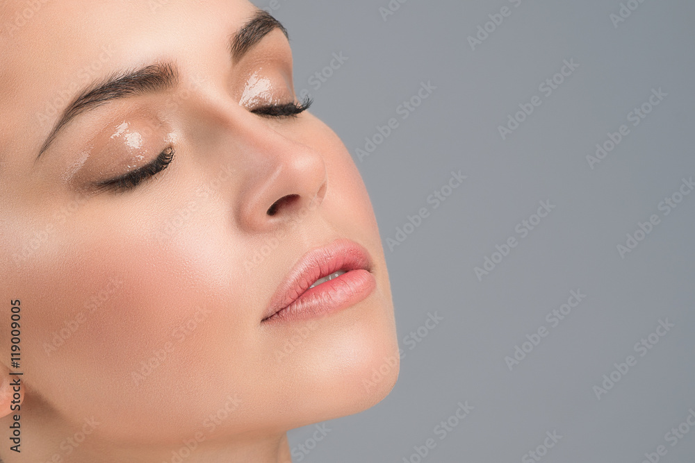 Portrait of a young girl's face with perfect skin and nude wet make up. Skin care concept. Close up. Studio shot. Copy-space. Portrait of a young girl's face with perfect skin and nude wet make up. Skin care concept. Close up. Studio shot. Copy-space.