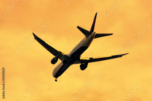 Airplane landing at sunset photo
