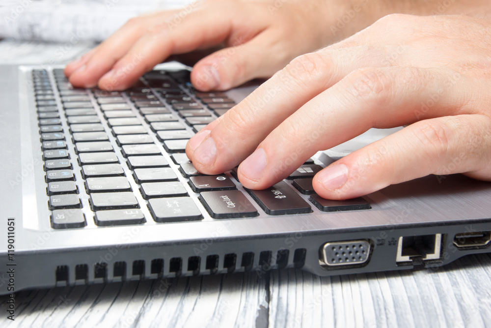 Man's hands typing laptop keyboard making online payment at home against the wooden table. On-line shopping concept. Selective focus, computer pc Man's hands typing laptop keyboard making online payment at home against the wooden table. On-line shopping concept. Selective focus, computer pc