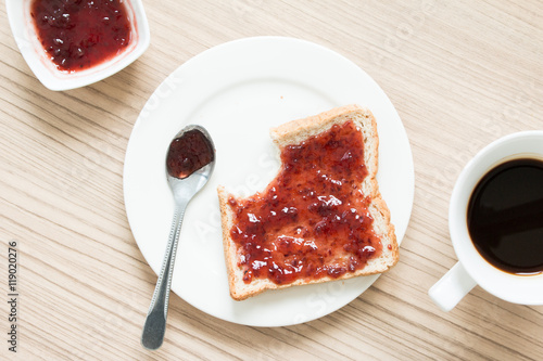 Bitten bread with strawberry jam photo