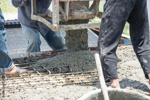 worker pouring concrete works at construction site
