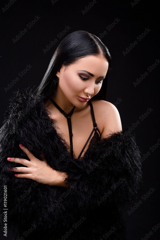Beautiful brunette in black dress with perfect decollete over black background. Elegant and gorgeous vampire in studio. Beautiful brunette in black dress with perfect decollete over black background. Elegant and gorgeous vampire in studio.