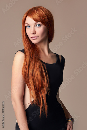 Elegant fashion photo of glamor beautiful young woman in dress posing in the studio,luxury.beauty red hair girl