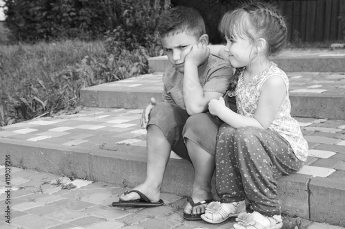 Summer outdoor girl comforting a sad boy. Black and white photo.