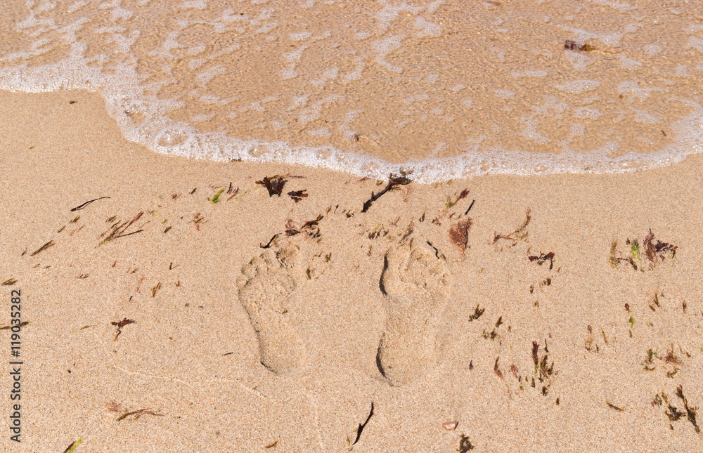 Footprints on the sandy beach in summertime