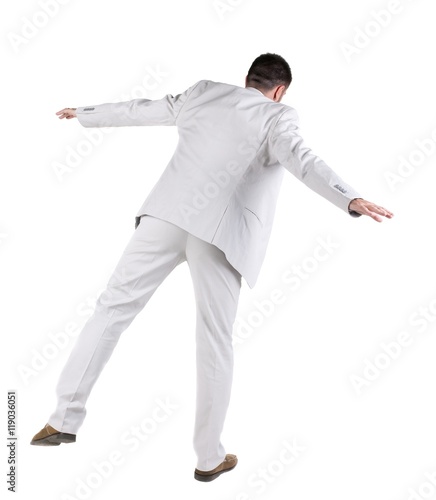 Balancing businessman . Rear view. Isolated over white background 