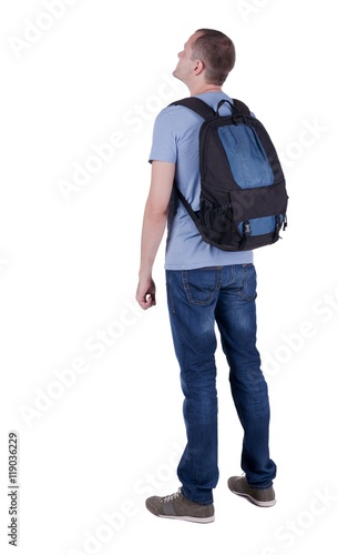Back view of man with  backpack looking up. Rear view people collection.  backside view of person.  Isolated over white background. guy in the green t-shirt stands with a suitcase on wheels
