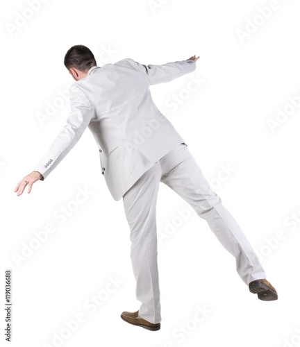 Balancing businessman . Rear view. Isolated over white background 