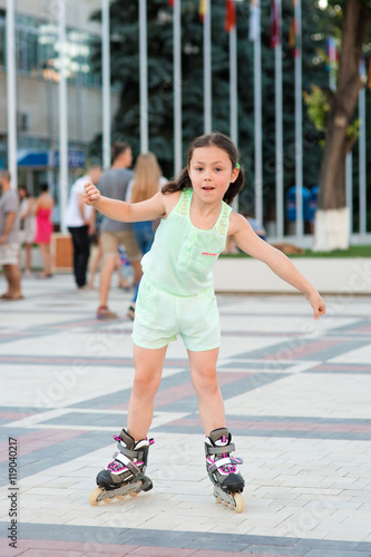 Little pretty girl on roller skates at a park © Aleksey