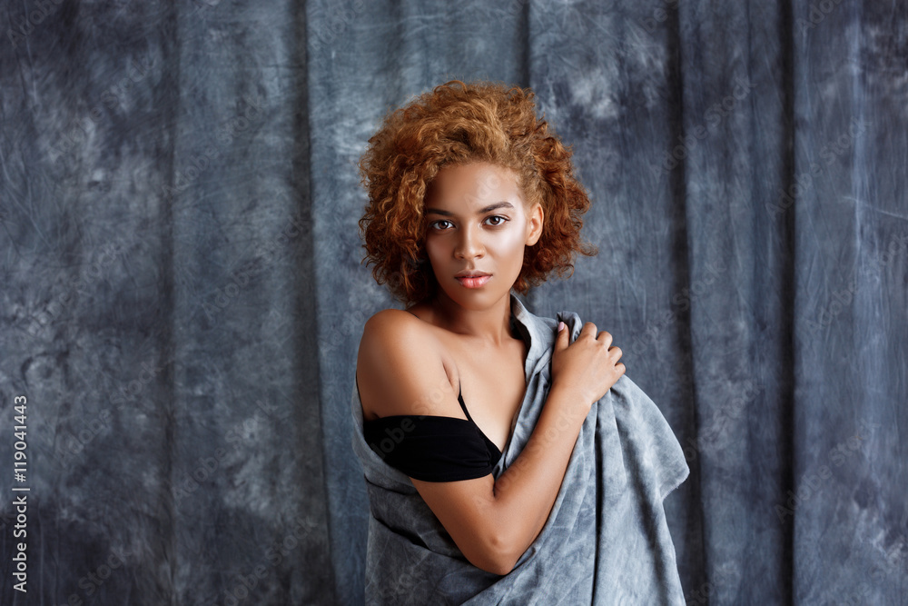 Young beautiful african girl posing, wrapping up in grey cloth. Young beautiful african girl posing, wrapping up in grey cloth.
