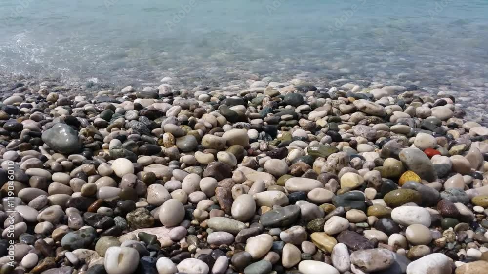 Pebble beach of the beautiful sea with small waves Pebble beach of the beautiful sea with small waves