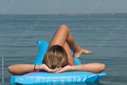 Beautiful young woman relaxing on inflatable mattress.