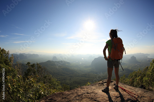 successful woman backpacker hiking on mountain peak