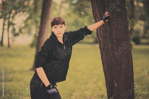 Young girl standing near tree in sports