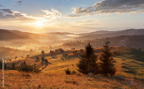 Fototapeta Naklejka Na Ścianę i Meble -  Sun moutain forest fog landscape at sunset on meadow