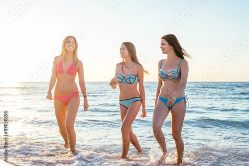 three girls having fun on beach  friends on beach in sunset light