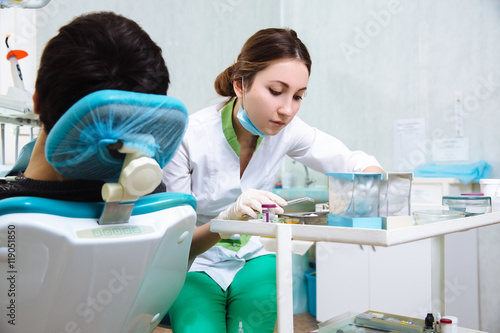 Female dentist with male patient at dental office. Concept of healthy